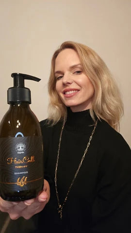 Usmiata zákazníčka s blond vlasmi drží šampón HairCell Therapy